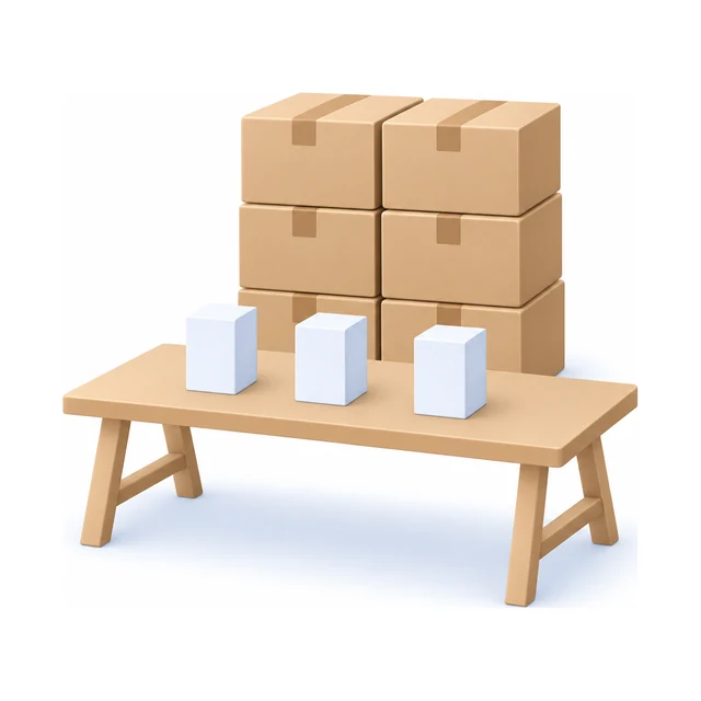 Three small boxes on a trestle table, with six sealed cartons stacked behind it